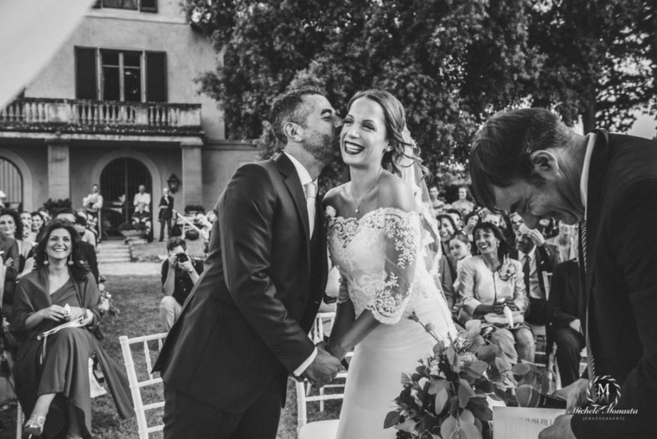 groom kiss bride while smiling happy