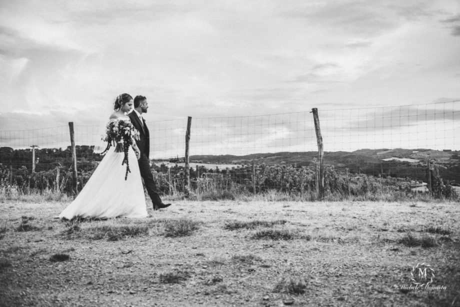 bride and groom walk together on their wedding day in tuscany