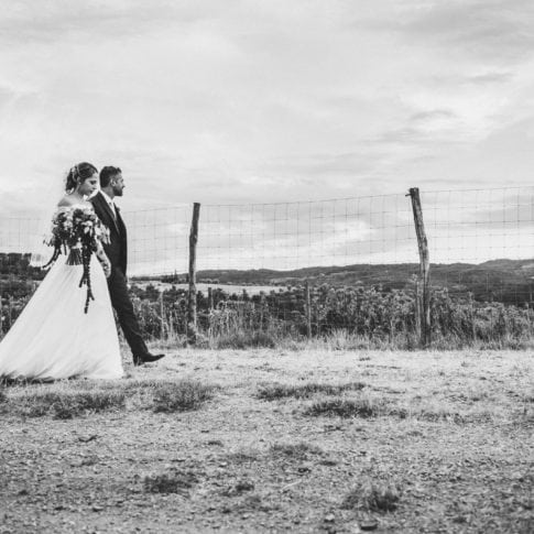 bride and groom walk together on their wedding day in tuscany