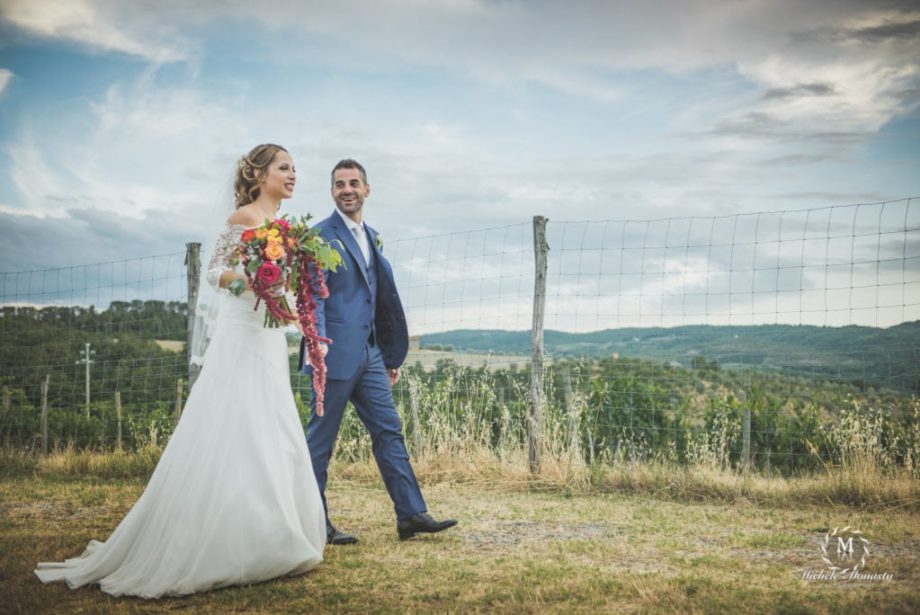 coppia di sposi sorridente nella campagna toscana il giorno del matrimonio