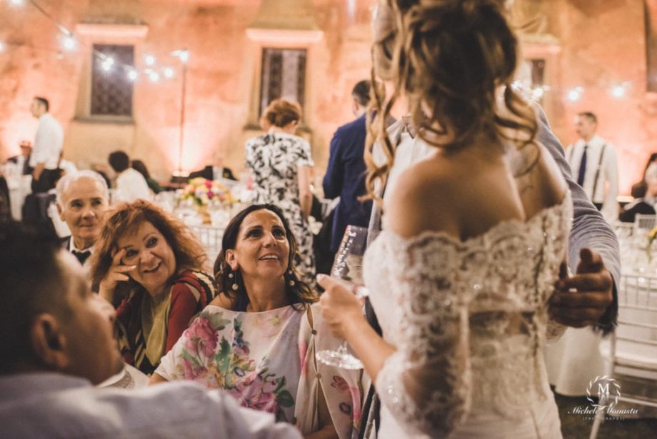 Amici e parenti sorridono alla sposa e allo sposo la sera del matrimonio